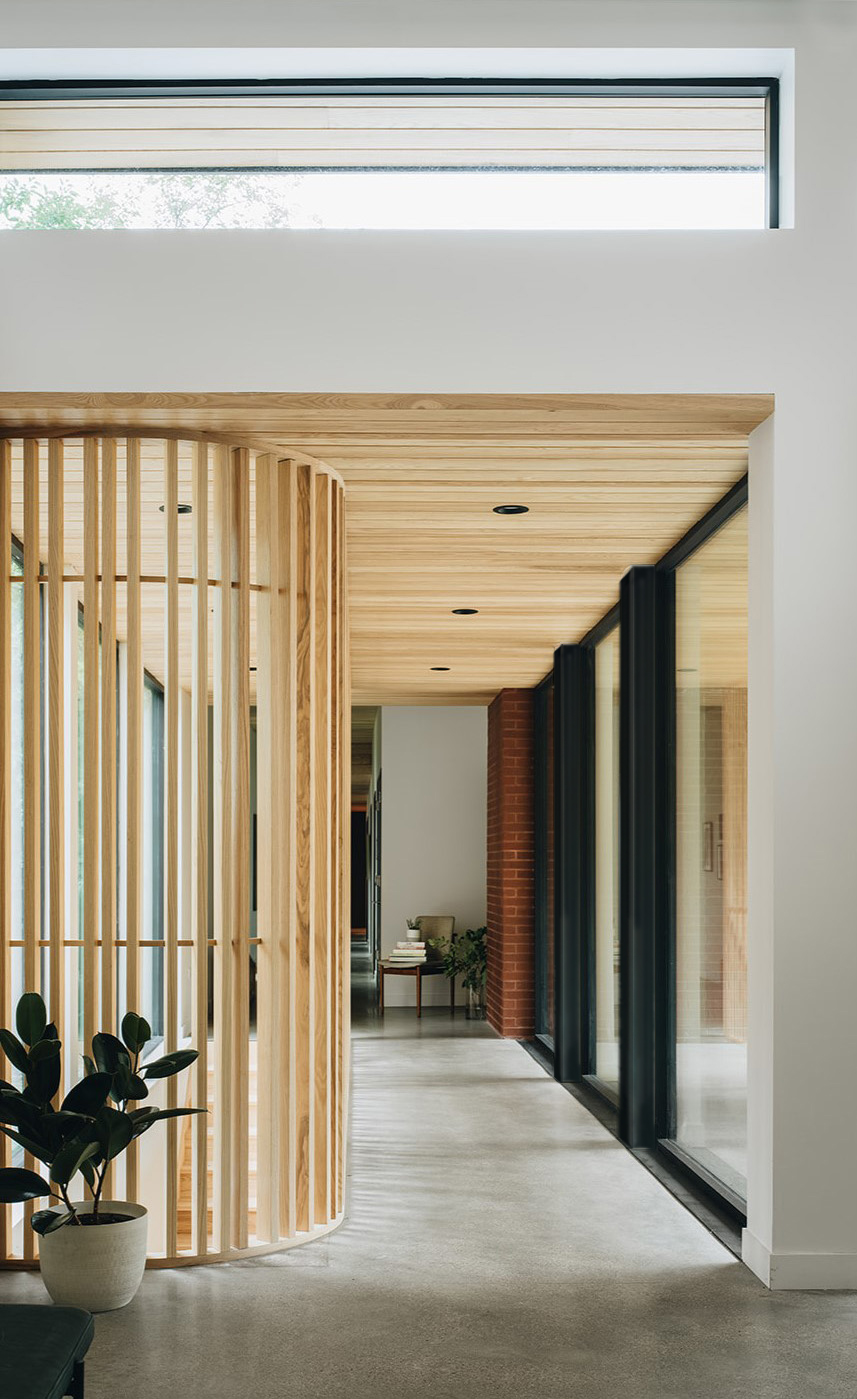hallway with wooden accents leading to a stairwell hallway with wooden accents leading to a stairwell